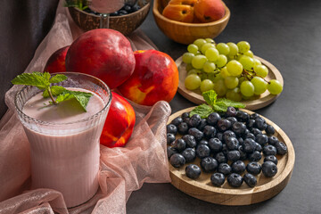 A thick blueberry smoothie displays its deep purple color with small pieces of skin visible, betraying its natural origin.