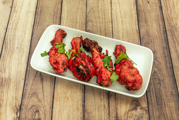 A feast for the eyes and palate: the image reveals the texture of the Tandoori chicken and its classic accompaniment of fresh vegetables and herbs