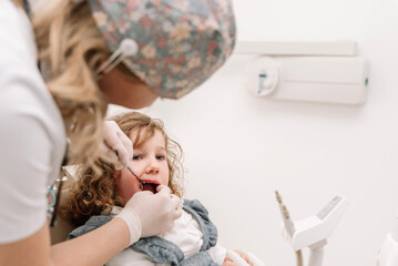 Dentist examining a child's teeth in a dental clinic