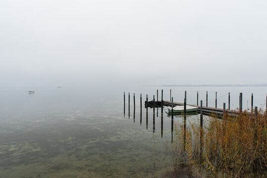Moody foggy lake scene with wooden dock, Lake Constance, Canton of Thurgau, Switzerland