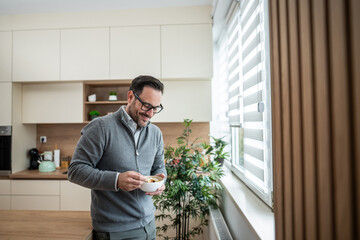 Man enjoying healthy breakfast in modern kitchen at home