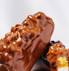 Chocolate-covered treats with a creamy filling displayed on a plain surface