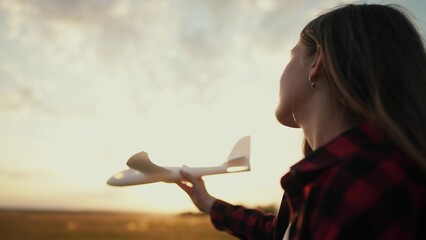 little girl running in the park with a toy airplane. happy family kid dream future concept. child girl silhouette plays with a toy airplane lifestyle runs on the grass in the summer in the park