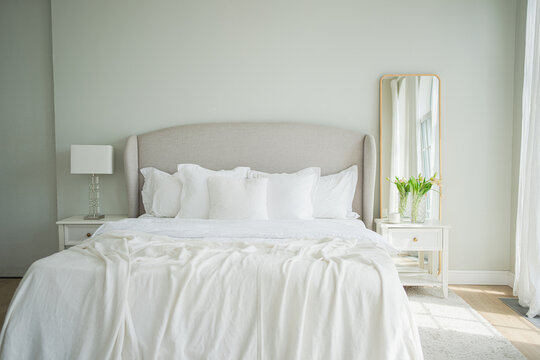 Stylish loft bedroom interior. Spacious design apartment with light walls large windows big bed. Clean modern decoration with elegant furniture in minimalist Scandinavian style - Powered by Adobe