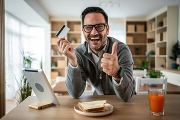 Happy man successfully making online shopping payment