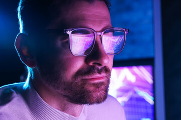 Man wearing glasses with reflection in dark room, closeup. Space for text