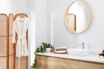 Stylish bathroom interior with mirror, folding screen and vessel sink