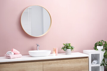 Stylish bathroom interior with mirror, vessel sink and houseplants