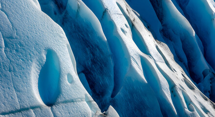 Close-up abstract detail of deep blue glacial ice and white snow formations.