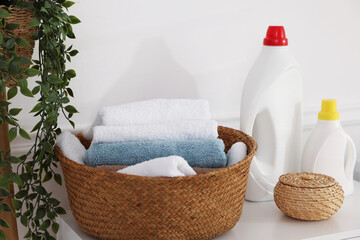 Laundry basket with towels and detergents on white cabinet indoors, closeup