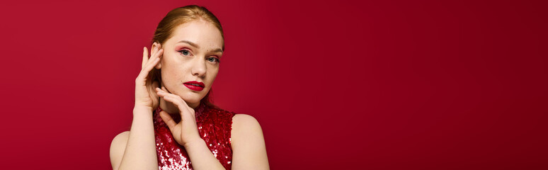 Enchanting young woman poses gracefully against a vibrant red backdrop