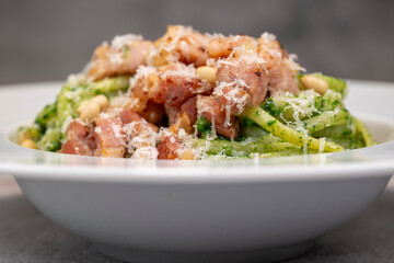 Recipe for linguine pasta with spinach pesto, smoked bacon, and Parmesan cheese. High quality photo