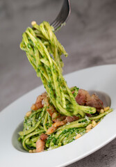 Recipe for linguine pasta with spinach pesto, smoked bacon, and Parmesan cheese. High quality photo