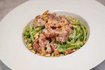 Recipe for linguine pasta with spinach pesto, smoked bacon, and Parmesan cheese. High quality photo