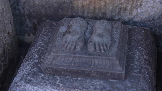 footprints carved on stone outside temple. Indian culture and religion.