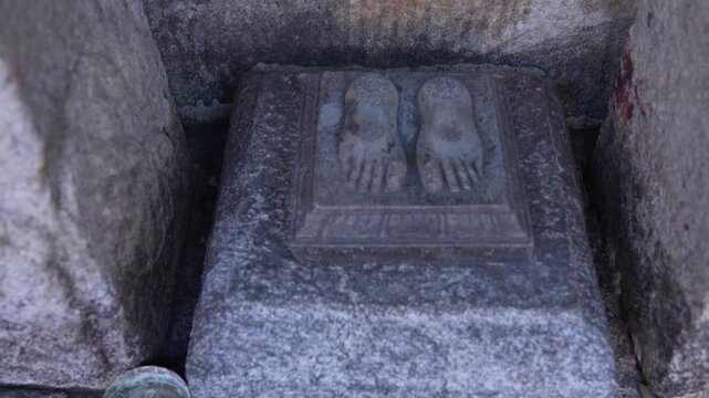 footprints carved on stone outside temple. Indian culture and religion.