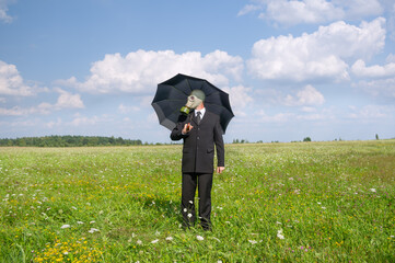 A man in a business suit on the green meadow.