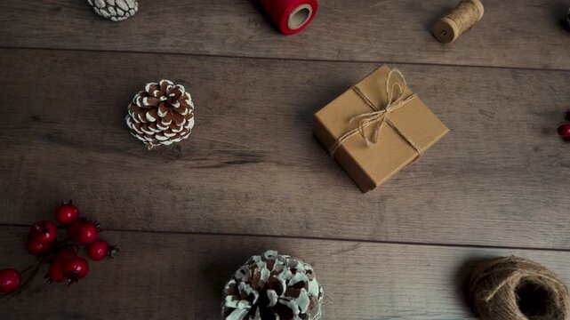 Slow-motion sliding shot to the right, featuring a handmade gift centered in the composition on a wooden surface with winter decorations