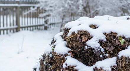 Compost pile covered in snow during winter in a quiet garden  