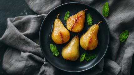 Sweet caramelized pears, a gourmet fruit dessert, beautifully arranged on a black plate with fresh mint leaves for decoration