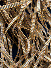 A dull gold textured gota lace bunch with soft metallic tones and intricate detailing, reflecting a rich traditional handcrafted finish.