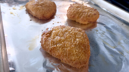 Three crispy breaded chicken breasts on foil