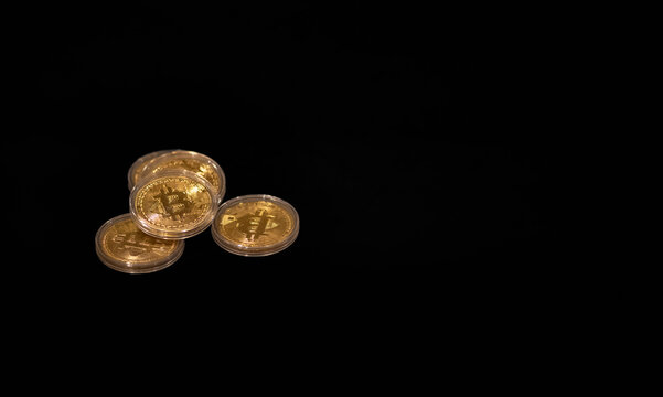 Physical bitcoin coins with copy space at the right on a black background 