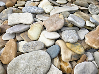 Colorful smooth stones cover the ground in a natural setting with space for additional text or decoration