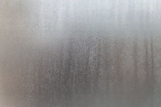 A close up of a glass window with water droplets on it