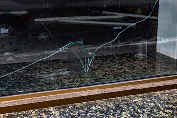 A broken glass window with the word Hikki Apple written on it