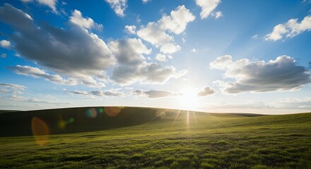 Green field under a cloudy blue sky at sunset time