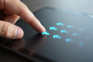 Index Finger Points at Blue Arrow Among Many on Tablet Exactly 150 Characters