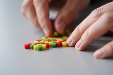 Human Hands Assembling Colorful Cylinder Shapes Together on Table Top Close Up in Studio for Creative Composition 150 Characters
