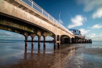 Extremely long exposure shot of Bournemouth Pier looking up.  Wide angle. Sunny Winter's day. Deserted beach
