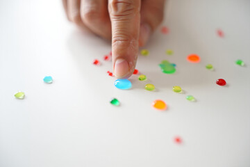 Person's Hand Touching Blue Liquid Drops on White Surface Colorful Abstract Concept of Art Water Experiment and Creative Science 150 Characters
