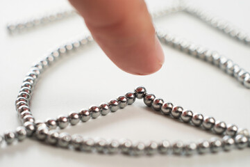 Finger Pressing on Silver Magnetic Balls Forming Structure Macro Shot Sphere Shape Magnetism Science Creative Toys Desk Toy