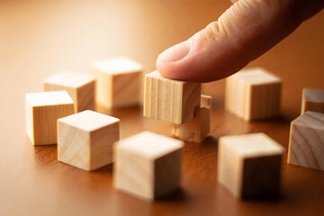 Hand Setting Wooden Cube Among Group in Strategic Arrangement Emphasizing Selection Choice Planning and Decision Making Process