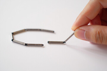 Hand Connecting Metal Cylinders for Assembly or Chain Link Concept on White Background 150 Characters