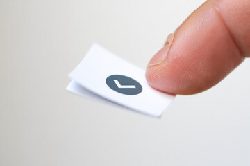 Paper Tick Held by Finger on Off White Background Confirm or Approve Choice Success Approval Tick Box Voting Feedback Concept Close Up Shot