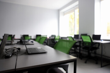 Blurred view of computer stylish class with laptops at school