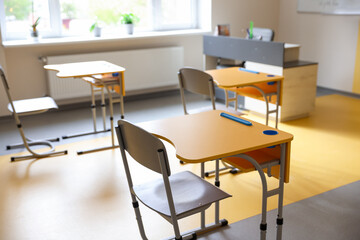 Yellow desks and chairs in classroom at school