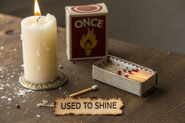 Melted candle beside matchbox and matches with sentimental tag