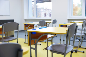 Stylish classroom with desks and chairs at school, closeup