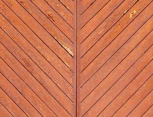 close-up shows a weathered wooden surface featuring diagonal patterns. The rich brown tones highlight natural wear and imperfections, enhanced by sunlight
