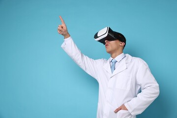 Modern technology. Doctor using virtual reality headset on light blue background, space for text