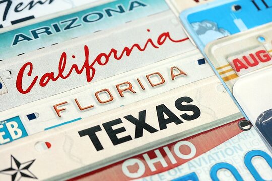 Old US car license plates with various state names. Concept of driving in United States. Reaching a car registration