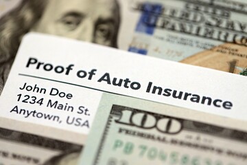 Proof of auto insurance card and many hundred dollar bills. Concept of insurance policy and car...