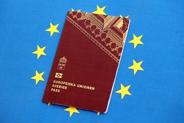 Swedish biometrical passport on European Union flag background. Concept of citizenship of Sweden