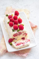 Raspberry dessert served on a plate with fresh berries and nuts at a cozy kitchen table in the afternoon