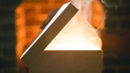 Hand opens Christmas gift package with smoke coming out from inside